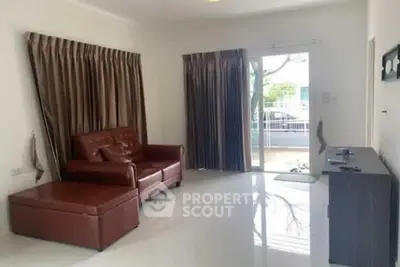 Spacious living room with leather sofa and large window for natural light
