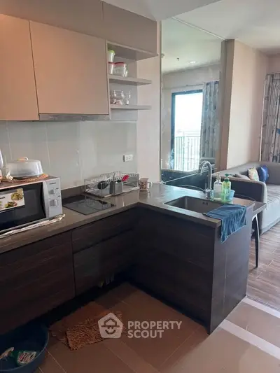 Modern kitchen with open layout and cozy living room in stylish apartment