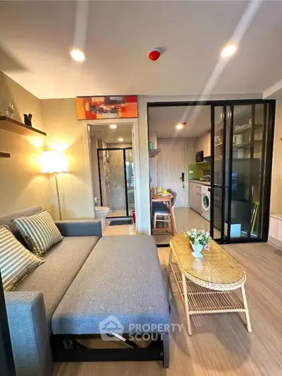 Modern living room with cozy sofa, stylish decor, and open kitchen layout in a chic apartment.