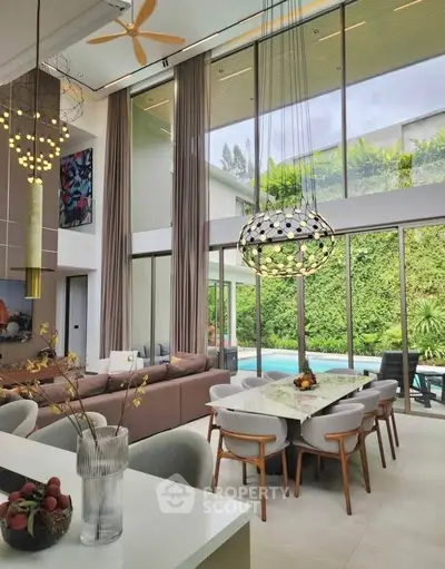Luxurious modern living room with high ceilings, elegant dining area, and pool view through large windows.