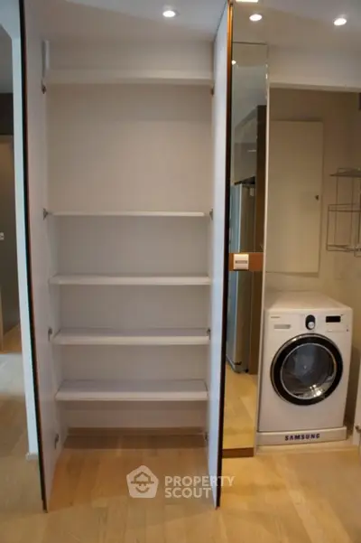 Modern laundry area with built-in shelving and Samsung washing machine