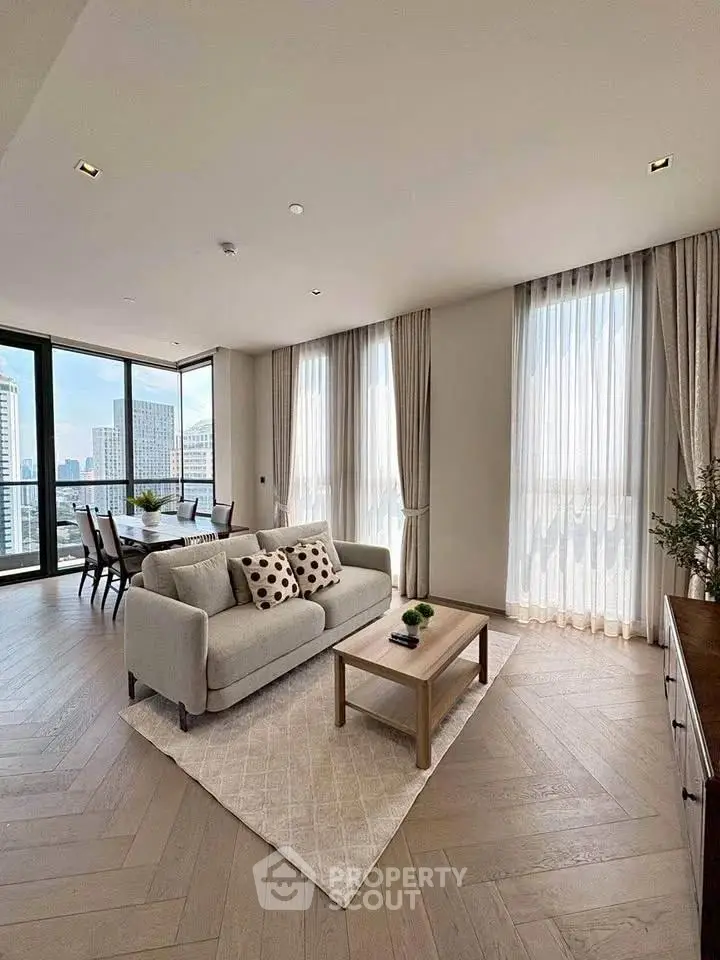Luxurious living room with city view, elegant decor, and abundant natural light in a modern apartment.