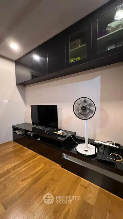 Modern living room with sleek black cabinetry and wooden flooring