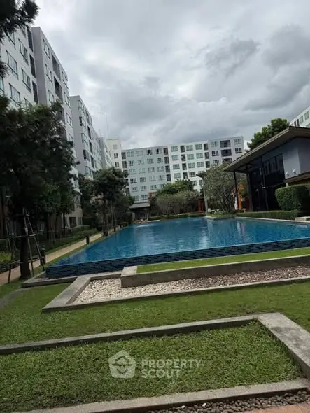 Modern apartment complex with a luxurious swimming pool and landscaped garden.