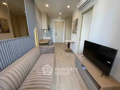 Modern living room with stylish sofa and flat-screen TV in a cozy apartment setting.