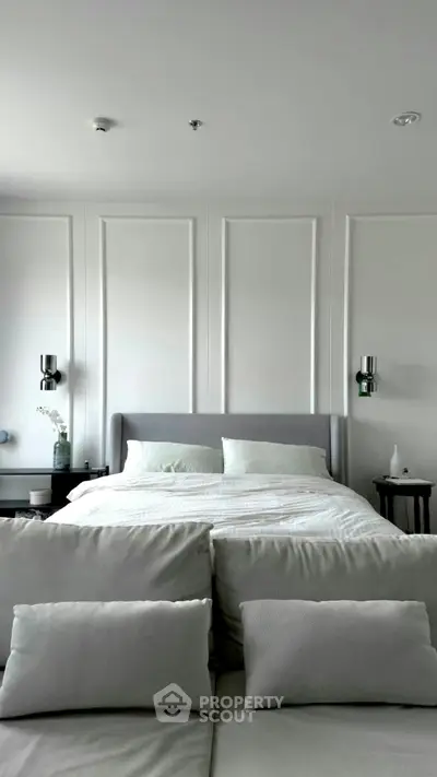Luxurious bedroom with elegant paneling and plush bedding in modern apartment.