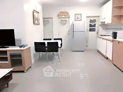 Modern open-plan living room and kitchen with sleek furniture and appliances.