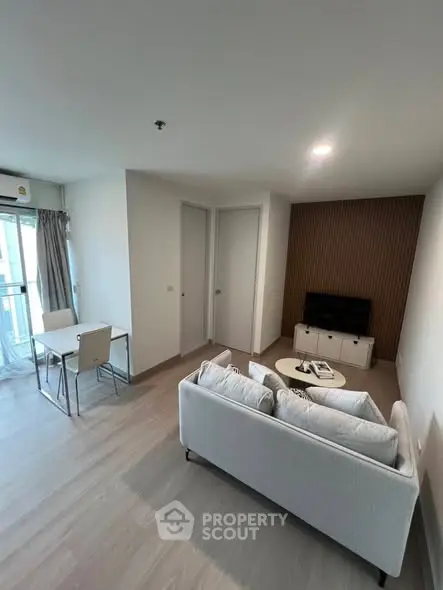 Modern living room with cozy sofa and dining area in a bright apartment.