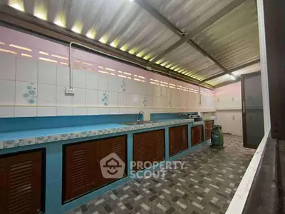 Spacious kitchen with tiled countertops and ample storage in a modern home.