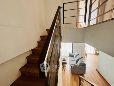 Modern duplex interior with wooden staircase and cozy living area