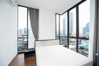 Modern bedroom with panoramic city views and floor-to-ceiling windows