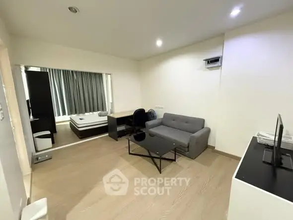 Modern living room with sleek furniture and open layout, featuring a cozy sofa and stylish decor.