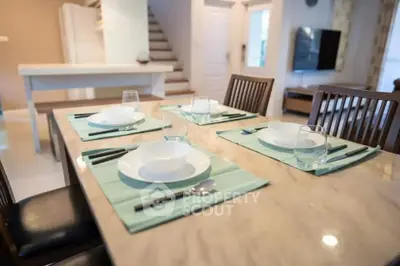 Elegant dining area with modern table setting in a stylish open-plan living space.