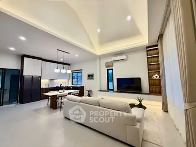 Spacious modern living room with open kitchen and elegant lighting