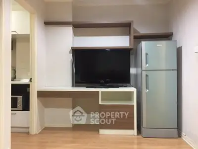 Modern living room with TV and fridge, sleek shelving and wooden flooring.