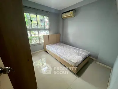 Cozy bedroom with large window and air conditioning in modern apartment