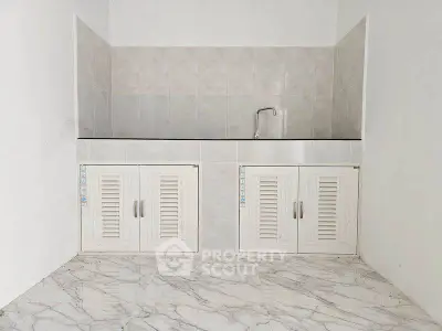 Minimalist kitchen area with marble flooring and white cabinetry