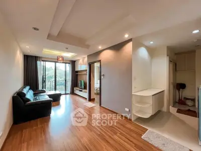 Spacious living room with wooden flooring and balcony view in modern apartment