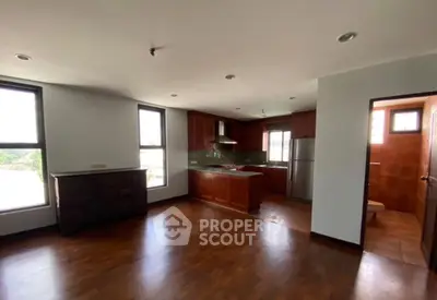 Spacious open-layout kitchen with wooden cabinets and ample natural light