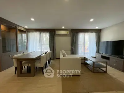 Spacious modern living room with elegant dining area and large windows for natural light.
