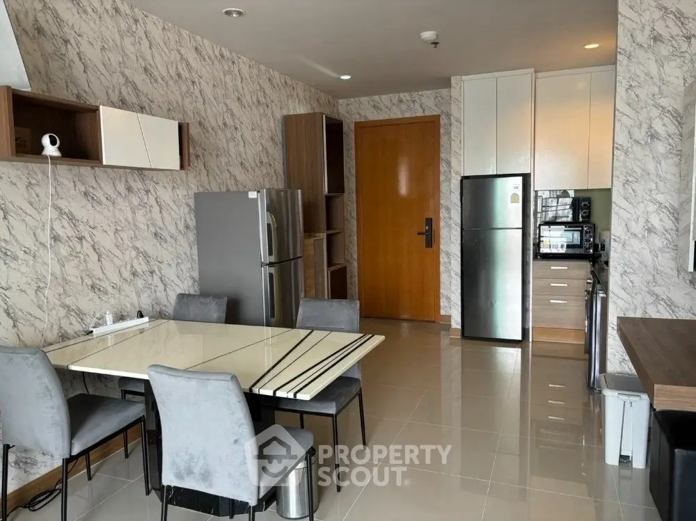Modern kitchen with marble walls, stainless steel appliances, and sleek dining area.