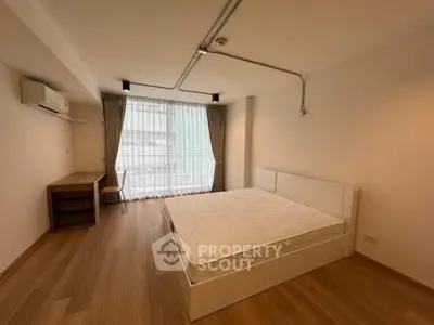 Spacious bedroom with natural light and modern furnishings