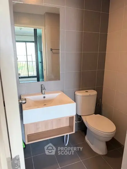 Modern bathroom with sleek fixtures and large mirror in a contemporary apartment.