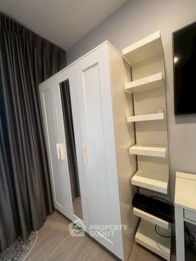 Modern bedroom with sleek white wardrobe and stylish shelving unit