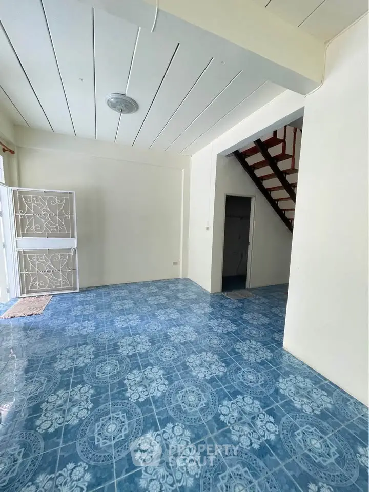 Spacious interior with blue patterned tile flooring and staircase, ideal for creative home design.