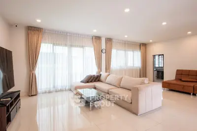 Spacious modern living room with elegant sofa and large windows