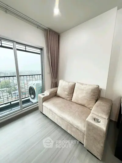 Modern living room with cozy sofa and balcony view in high-rise apartment.