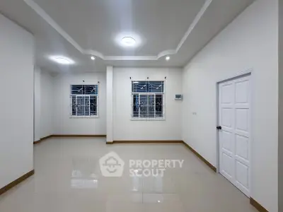 Spacious and bright living room with modern ceiling lights and large windows.