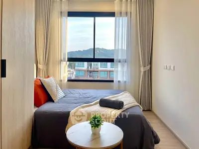 Cozy bedroom with large window offering scenic views, modern decor, and natural light.