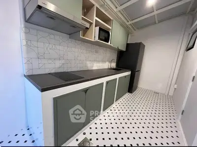 Modern kitchen with sleek cabinetry and stylish backsplash in a contemporary apartment.