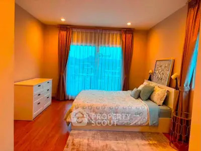 Cozy bedroom with elegant decor and large window offering natural light.