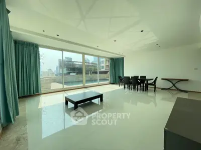 Spacious living room with floor-to-ceiling windows and modern dining area