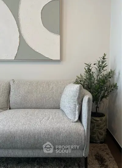 Stylish modern living room with elegant gray sofa and abstract wall art, perfect for contemporary home decor.