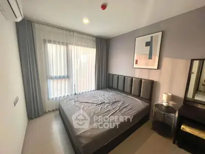 Modern bedroom with stylish decor and natural light, featuring a cozy bed and elegant furnishings.