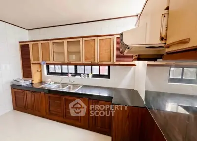 Spacious kitchen with wooden cabinets and sleek countertops in modern home.