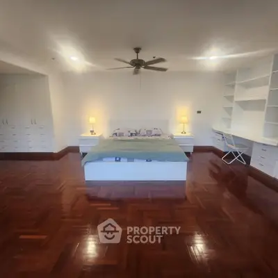 Spacious bedroom with wooden flooring and built-in storage