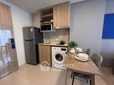 Modern kitchen with integrated appliances and dining area in a stylish apartment.