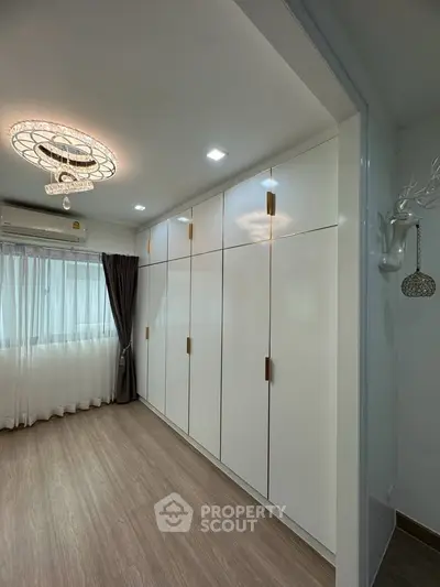 Spacious bedroom with elegant built-in wardrobes and modern lighting