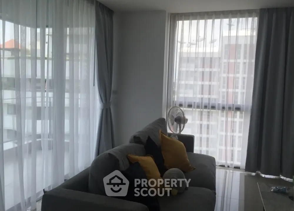 Modern living room with large windows and cozy sofa in a high-rise apartment
