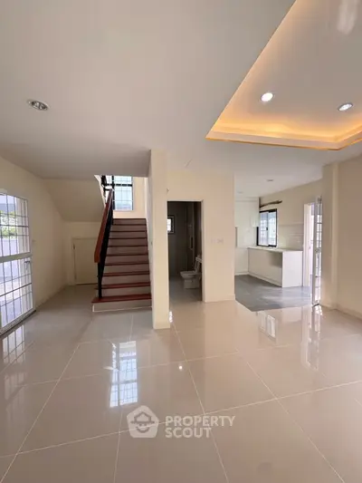 Spacious open-plan living area with modern kitchen and staircase