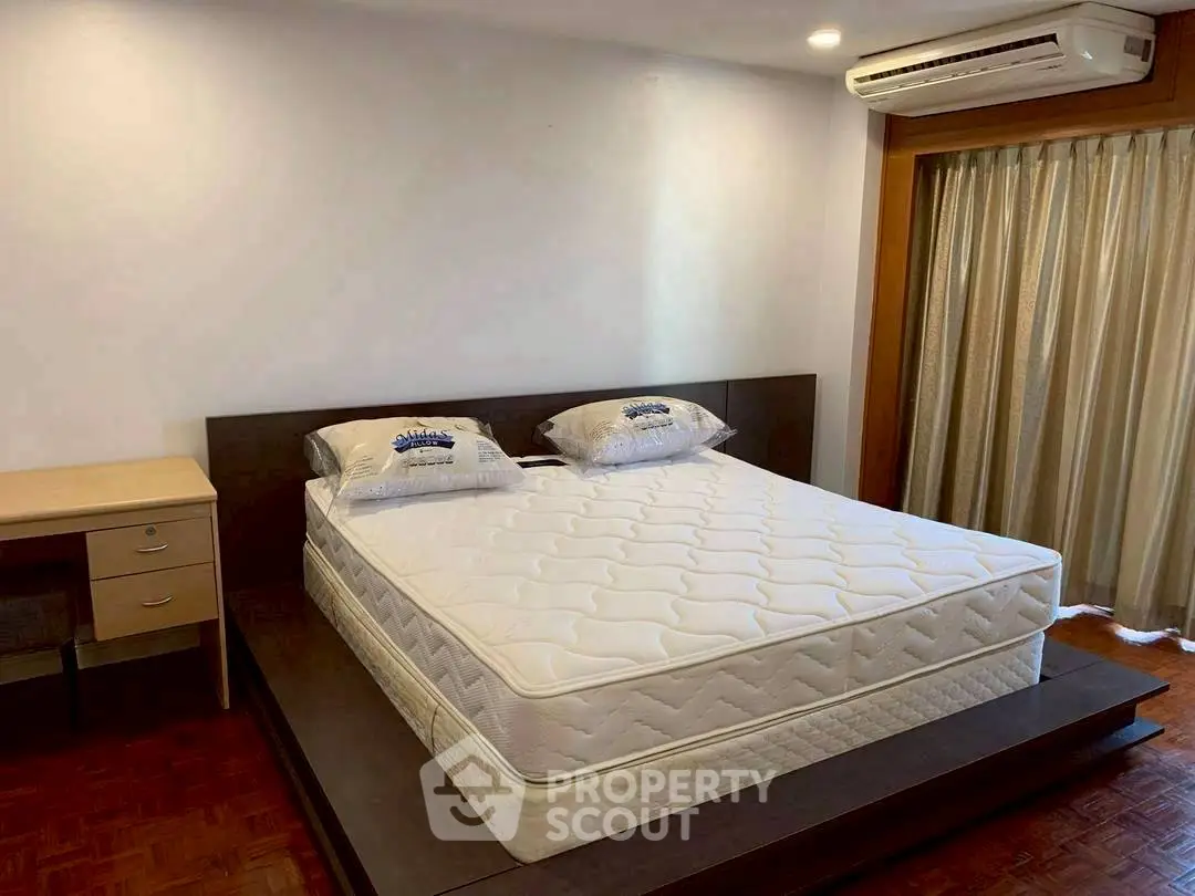 Spacious bedroom with modern design and comfortable bed in a well-lit apartment.