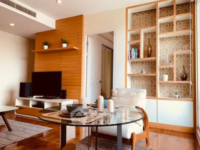Stylish living room with modern decor, wooden accents, and elegant shelving in a cozy apartment.