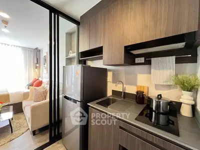 Modern kitchen with sleek cabinetry and open layout adjacent to cozy living room.