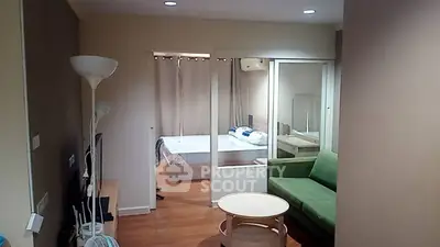 Modern studio apartment with cozy living area and bedroom, featuring stylish decor and ample natural light.