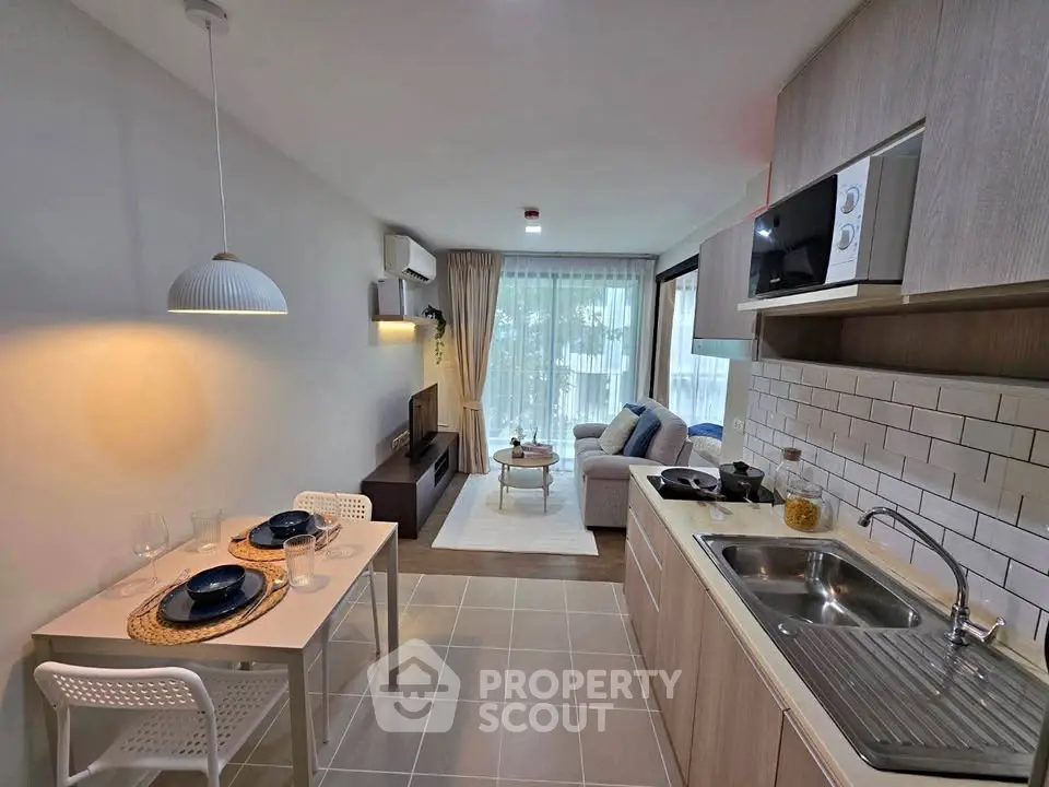 Modern open-plan kitchen and living room with stylish decor and natural light.
