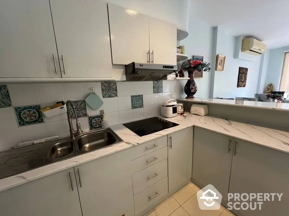 Modern kitchen with sleek cabinetry and marble countertops in a stylish apartment.